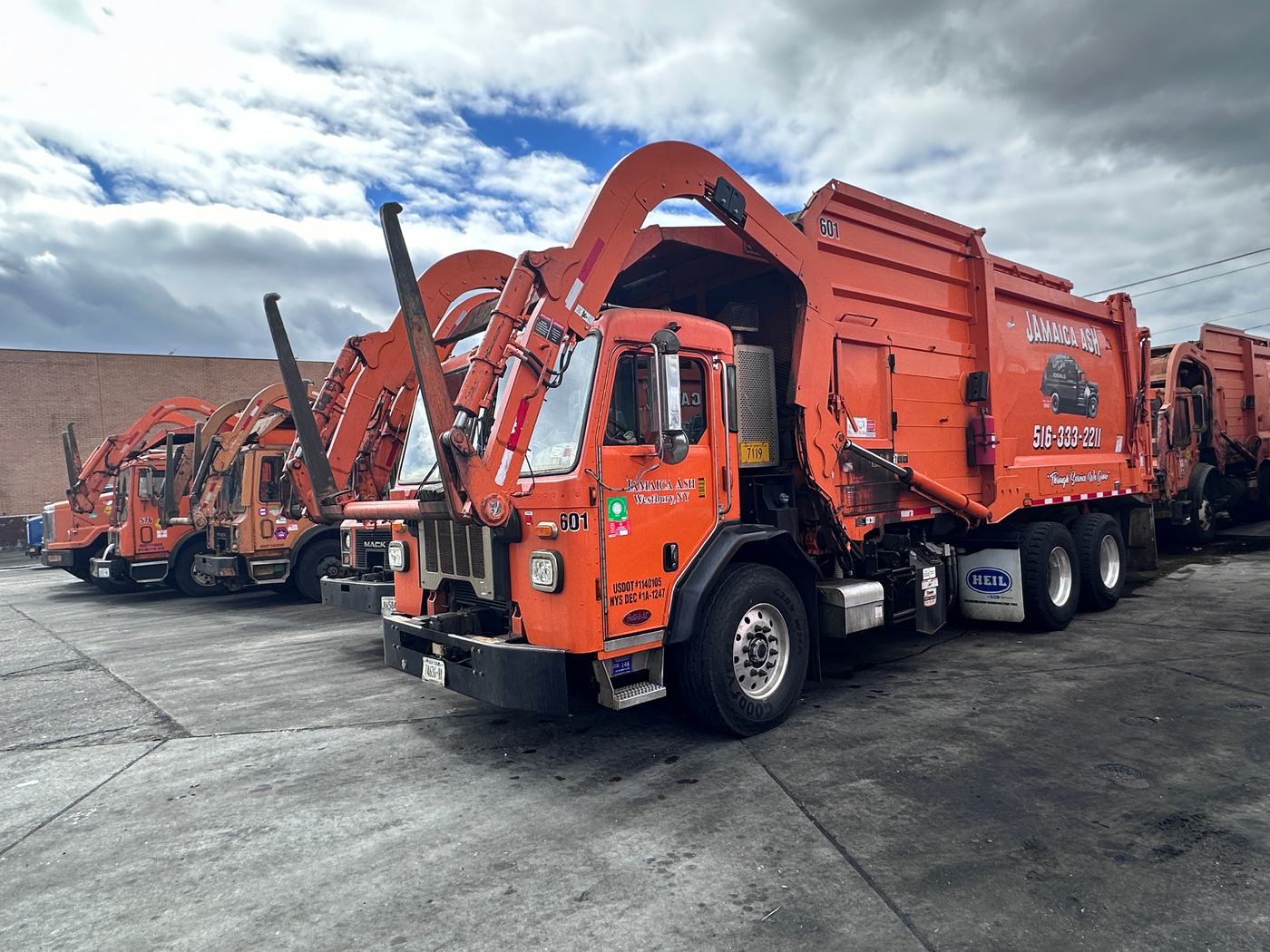 Jamaica Ash orange front-loader fleet lined up at the Westbury yard